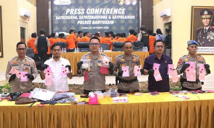 Polisi Ungkap Kilat Penembakan Sopir Angkot Banyuasin: 3 Pelaku Ditangkap Kapolres Banyuasin AKBP Ruri Prastowo (tengah) menunjukkan sejumlah barang bukti hasil pengungkapan 34 kasus kejahatan termasuk kasus penembakan dua angkutan sopir umum yang berhasil diungkap jajaran Polres Banyuasin selama periode September hingga Oktober 2025, Rabu (22/10/2025).