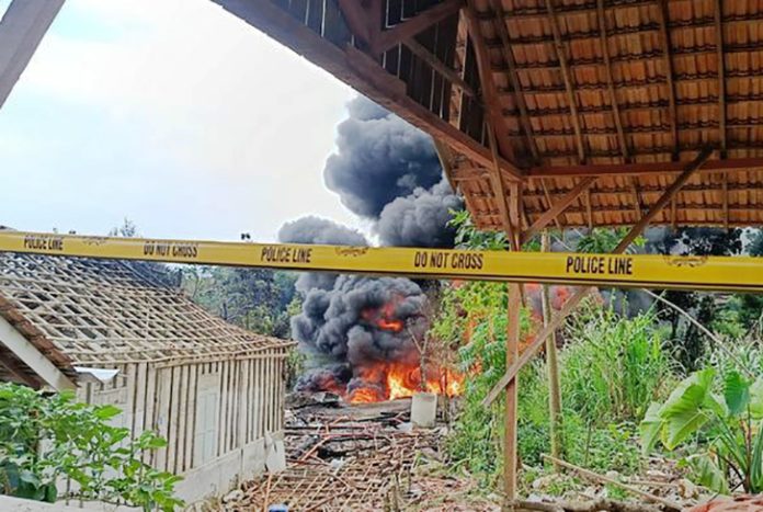 Kobaran api disertai asap hitam pekat masih terlihat membumbung tinggi dari lokasi sumur minyak ilegal di Desa Gandu, Kecamatan Bogorejo, Kabupaten Blora, Jawa Tengah, hingga Senin (18/8/2025) siang. (KOMPAS.COM/ARIA RUSTA YULI PRADANA)