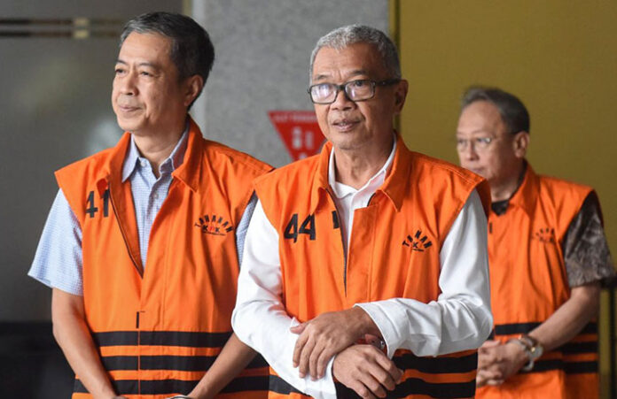 Tiga tersangka kasus dugaan pemerasan dalam pengurusan Rencana Penggunaan Tenaga Kerja Asing (RPTKA) di lingkungan Kementerian Ketenagakerjaan, Suhartono (tengah), Haryanto (kiri), dan Wisnu Pramono (kanan) berjalan menuju mobil tahanan saat pelimpahan tahap dua di Gedung Merah Putih KPK, Jakarta, Rabu (12/11/2025).