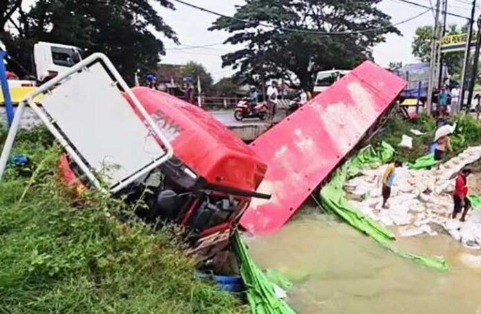 Truk Pupuk Alami Kecelakaan di Pantura Pati, Terperosok ke Sungai Sebuah truk trailer bermuatan pupuk mengalami kecelakaan tunggal hingga terperosok ke aliran sungai di jalur Pantura Pati-Rembang, tepatnya di Kali Ombo, Desa Ketitang Wetan, Kecamatan Batangan, Kabupaten Pati, Jawa Tengah, Sabtu (13/12/2025) dini hari.